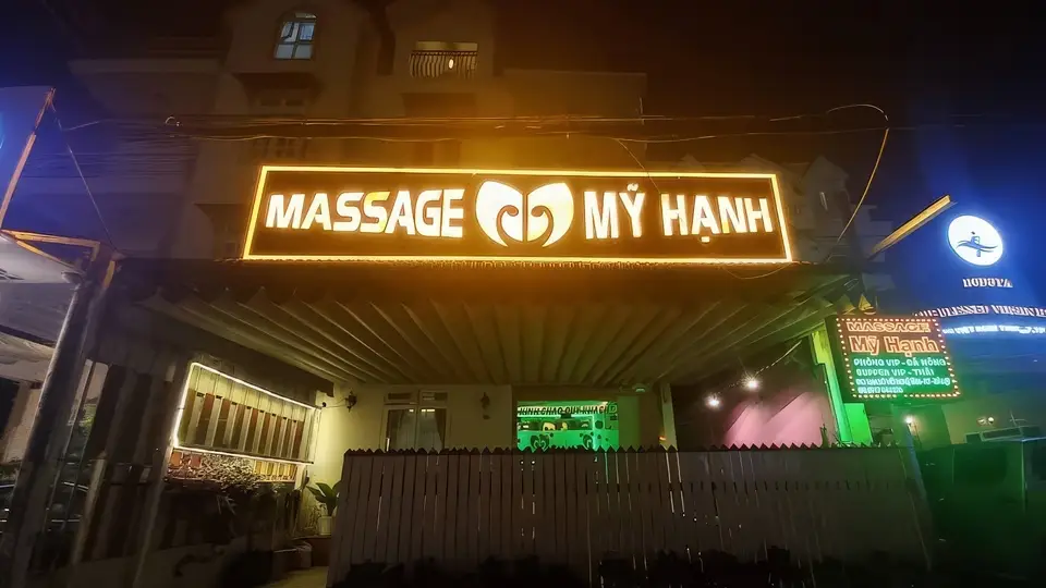 황금 네온사인이 빛나는 미한 마사지 건물 외관 야경