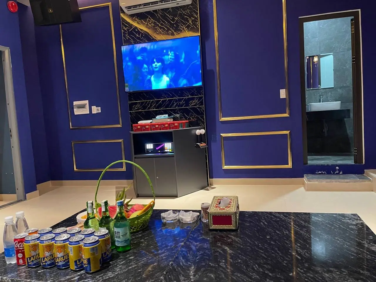 블루 & 골드 인테리어에 대형 스크린 TV, 노래방 기기, 블랙 대리석 테이블, 음료 세팅, 그리고 전용 화장실이 완비된 엔터테인먼트 룸