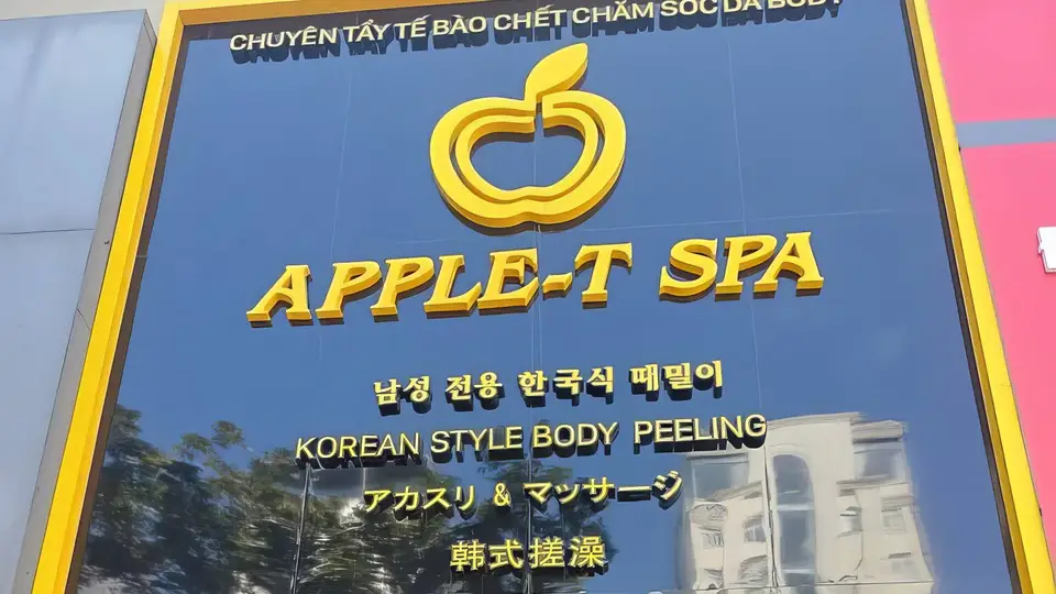 애플 스파의 골드 컬러 로고와 한국어·영어·일본어·중국어가 새겨진 네이비 블루 외관 간판