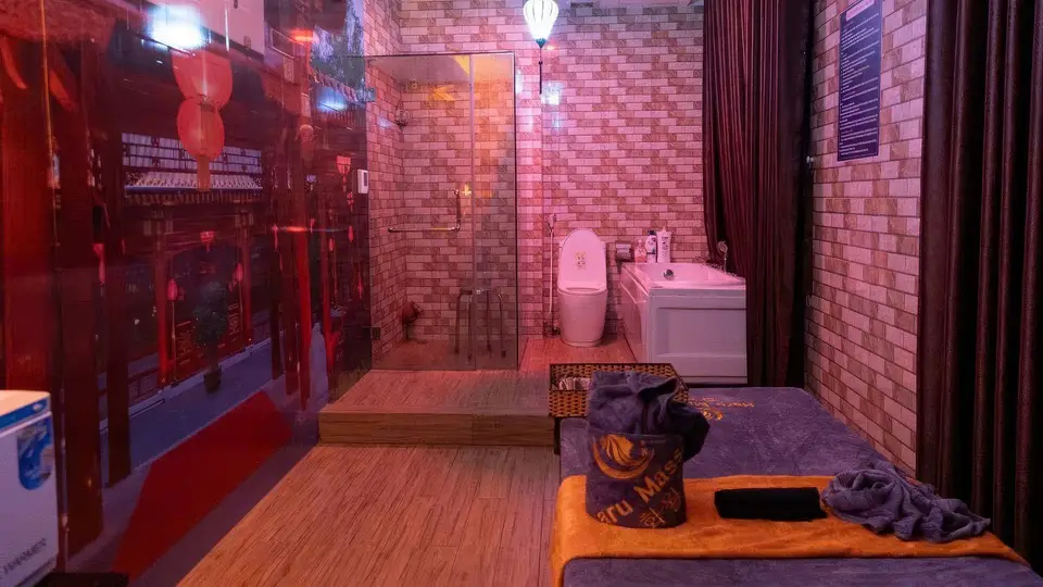 붉은 조명과 벽돌 인테리어, 유리 샤워 부스와 욕조 및 화장실이 통합된 화월루 VIP 스파 룸