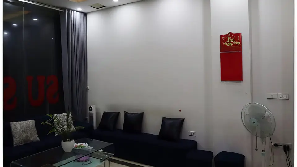 수 사우나의 다크 네이비 소파와 유리 테이블이 배치된 모던한 대기 라운지 내부