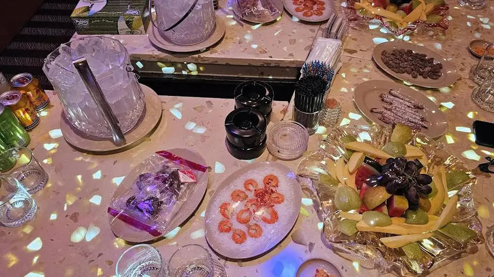새우, 견과류, 과일 플레이트와 얼음통이 세팅된 보스 가라오케의 테이블 클로즈업