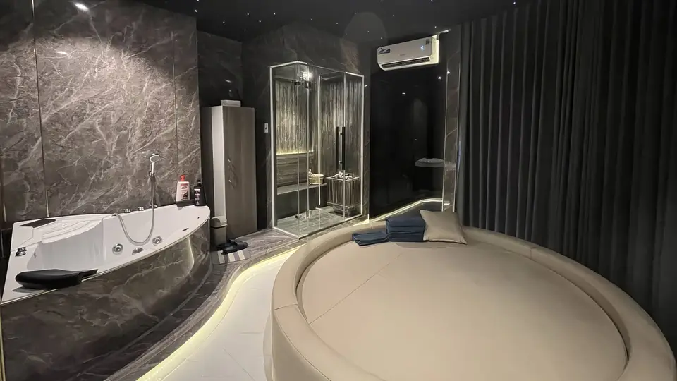 별빛 천장과 다크 마블 벽면, 코너 자쿠지 욕조와 유리 사우나 부스, 원형 마사지 침대가 갖춰진 VIP 스파 룸