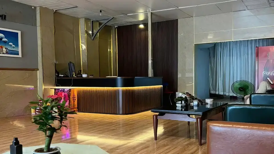 파인 마사지 입구 로비의 골드 언더라이팅이 돋보이는 우드 리셉션 데스크와 아늑한 대기 공간