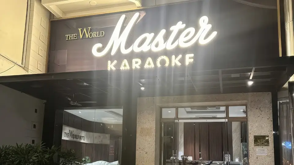 골드 컬러의 'Master Karaoke' 네온 사인과 대리석 외벽, 유리 출입문이 돋보이는 마스터 가라오케 정문 전경