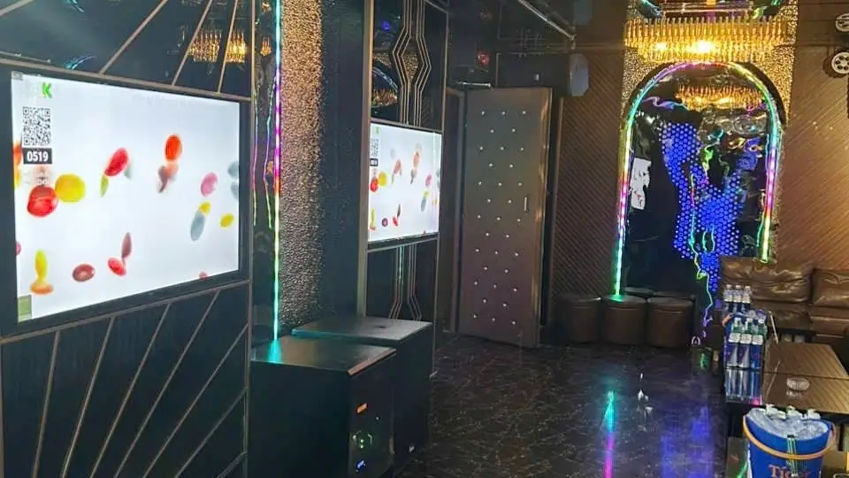 두 대의 대형 노래방 스크린과 골드 아치형 장식 게이트, 컬러 LED 조명이 어우러진 마스터 가라오케 룸 내부